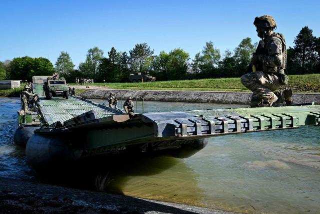 Members of France's 1st Tirailleur Regiment cross Lake Amance, during a training session as part of the ORION 26 military exercise in Radonvilliers, northeastern France, on April 22, 2026. (Photo by Jean-Christophe VERHAEGEN / AFP)