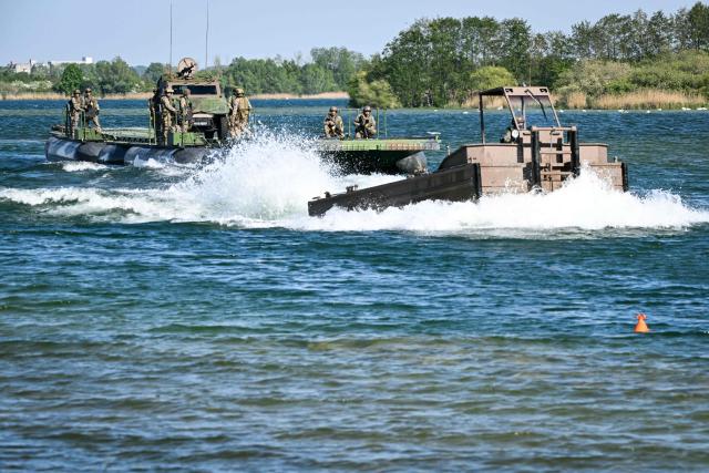 Members of France's 3rd Engineer Regiment deploy a forward crossing apparatus (also known as EFA or Engin de Franchissement de l'Avant) to allow members of France's 1st Tirailleur Regiment to cross Lake Amance, during a training session as part of the ORION 26 military exercise in Radonvilliers, northeastern France, on April 22, 2026. (Photo by Jean-Christophe VERHAEGEN / AFP)