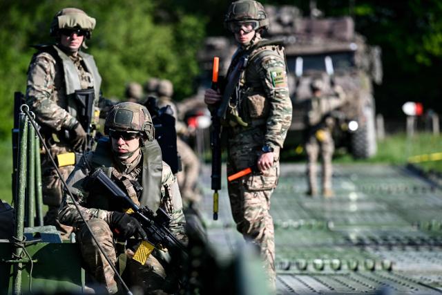 Members of France's 1st Tirailleur Regiment stand guard as they cross Lake Amance, during a training session as part of the ORION 26 military exercise in Radonvilliers, northeastern France, on April 22, 2026. (Photo by Jean-Christophe VERHAEGEN / AFP)