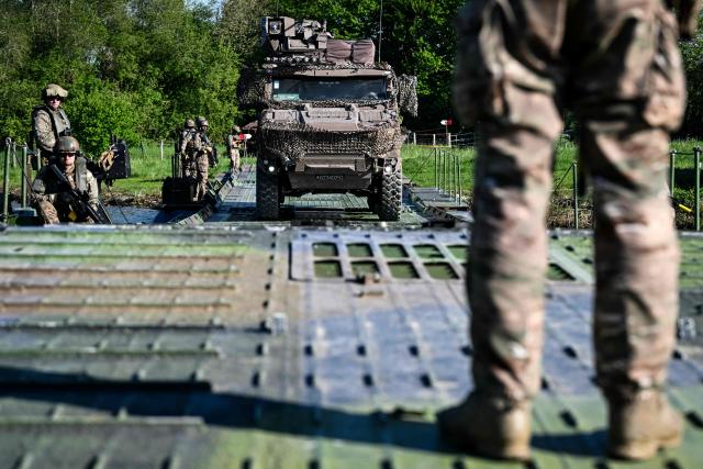 Members of France's 1st Tirailleur Regiment help an army vehicle to cross Lake Amance, during a training session as part of the ORION 26 military exercise in Radonvilliers, northeastern France, on April 22, 2026. (Photo by Jean-Christophe VERHAEGEN / AFP)