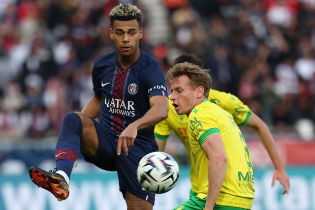 Paris Saint-Germain's French midfielder #14 Desire Doue (L) fights for the ball with Nantes' French defender #03 Nicolas Cozza during the French L1 football match between Paris Saint-Germain (PSG) and FC Nantes at the Parc des Princes stadium in Paris on April 22, 2026. (Photo by FRANCK FIFE / AFP)