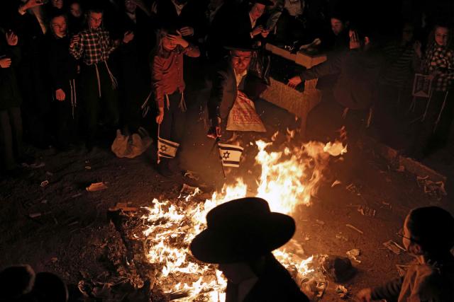 Members of the Neturei Karta, an international organisation of anti-Zionist Orthodox Jews, burn Israeli flags during a protest against the State of Israel, which they believe should not exist before the coming of the messiah, in the Jerusalem neighbourhood of Mea Shearim on April 22, 2026, as Israel celebrates its 78th Independence Day. (Photo by AHMAD GHARABLI / AFP)