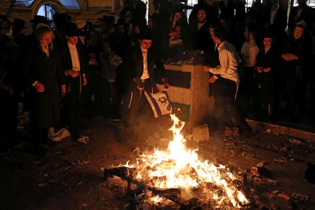 Members of the Neturei Karta, an international organisation of anti-Zionist Orthodox Jews, burn Israeli flags during a protest against the State of Israel, which they believe should not exist before the coming of the messiah, in the Jerusalem neighbourhood of Mea Shearim on April 22, 2026, as Israel celebrates its 78th Independence Day. (Photo by AHMAD GHARABLI / AFP)