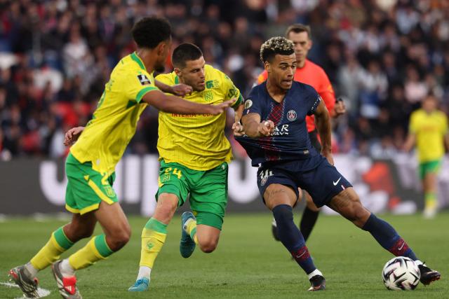 Nantes' French defender #24 Frederic Guilbert (C) fights for the ball with Paris Saint-Germain's French midfielder #14 Desire Doue during the French L1 football match between Paris Saint-Germain (PSG) and FC Nantes at the Parc des Princes stadium in Paris on April 22, 2026. (Photo by FRANCK FIFE / AFP)