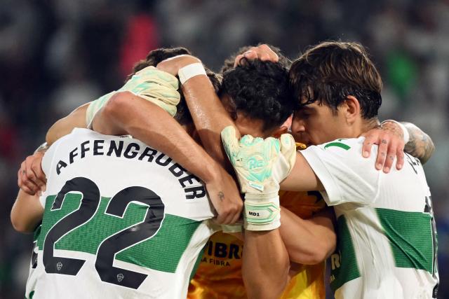 Elche players celebrate their victory at the end of the Spanish league football match between Elche CF and Club Atletico Madrid at Martinez Valero Stadium in Elche on April 22, 2026. (Photo by JOSE JORDAN / AFP)
