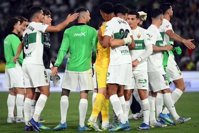 Elche players celebrate their victory at the end of the Spanish league football match between Elche CF and Club Atletico Madrid at Martinez Valero Stadium in Elche on April 22, 2026. (Photo by JOSE JORDAN / AFP)
