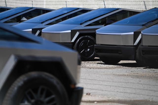 (FILES) Tesla Cybertruck electric vehicles sit parked in a storage lot in San Diego, California on April 11, 2025. Tesla reported higher first-quarter profits Wednesday, pointing to recovering demand in North America as it pursues significant investments in autonomous transport and artificial intelligence. (Photo by Patrick T. Fallon / AFP)