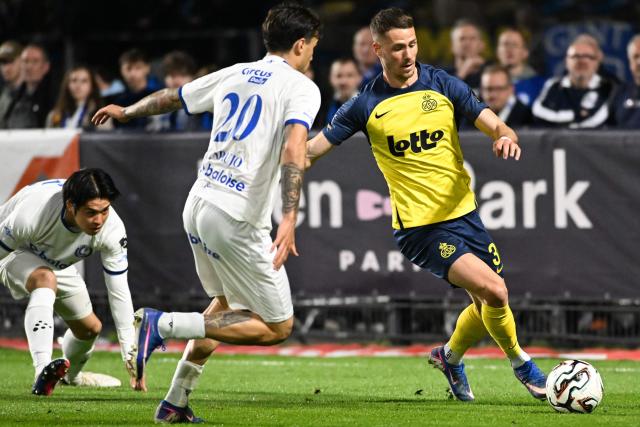 KAA Gent's Portuguese defender #20 Tiago Araujo (C) fights for the ball with Royale Union Saint-Gilloise's Austrian forward #30 Raul Florucz during the fourth day of the Champion's Play-offs of the 2025-2026 Belgian championship Pro League first division football match between Royale Union Saint-Gilloise (RUSG) and KAA Gent at the Joseph Marien Stadium in Brussels on April 22, 2026. (Photo by JILL DELSAUX / BELGA / AFP) / Belgium OUT