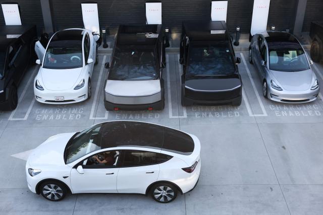 (FILES) Tesla electric vehicles, including the Cybertruck, charge at stations during the opening of the Tesla Diner and Drive-In restaurant and Supercharger on Santa Monica Blvd in the Hollywood neighborhood Los Angeles, California on July 21, 2025. Tesla reported higher first-quarter profits Wednesday, pointing to recovering demand in North America as it pursues significant investments in autonomous transport and artificial intelligence. (Photo by Patrick T. Fallon / AFP)