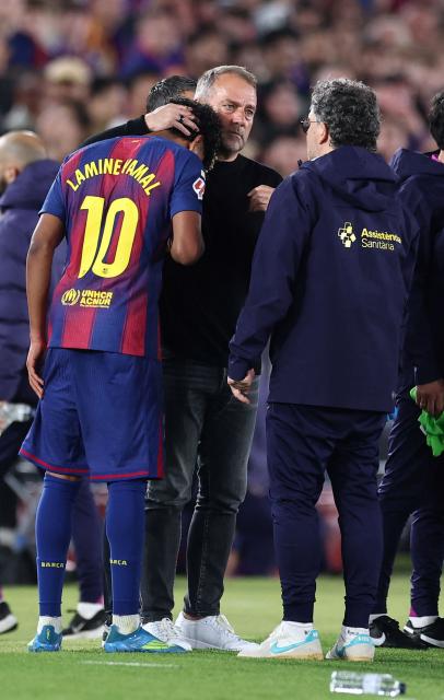 Barcelona's German coach Hans-Dieter Flick speaks with the team doctor as he hugs Barcelona's Spanish forward #10 Lamine Yamal after being substituted due to an injury during the Spanish league football match between FC Barcelona and RC Celta de Vigo at Camp Nou stadium in Barcelona on April 22 , 2026. (Photo by Josep LAGO / AFP)
