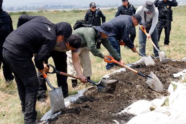 City authorities and relatives of missing persons search for human remains on the shores of Lake Chalco, in the Tlahuac borough of Mexico City, on April 22, 2026. Several groups searching for missing persons said on April 17 they had discovered more than 1,000 bone fragments in a lakeside area of Mexico City, where Mexican authorities have been excavating for more than a week. (Photo by GERARDO MAGALLON / AFP)