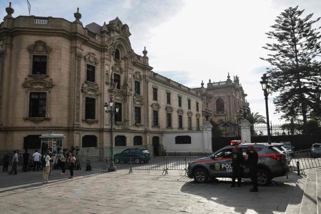 Police and media members remain outside the Government Palace in Lima on April 22, 2026. Peru's foreign and defense ministers resigned on April 22 in protest over the interim president's decision to stall a $3.5 billion deal for the purchase of 24 US F-16 fighter jets. (Photo by Connie FRANCE / AFP)
