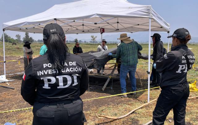 City authorities and relatives of missing persons search for human remains on the shores of Lake Chalco, in the Tlahuac borough of Mexico City, on April 22, 2026. Several groups searching for missing persons said on April 17 they had discovered more than 1,000 bone fragments in a lakeside area of Mexico City, where Mexican authorities have been excavating for more than a week. (Photo by GERARDO MAGALLON / AFP)
