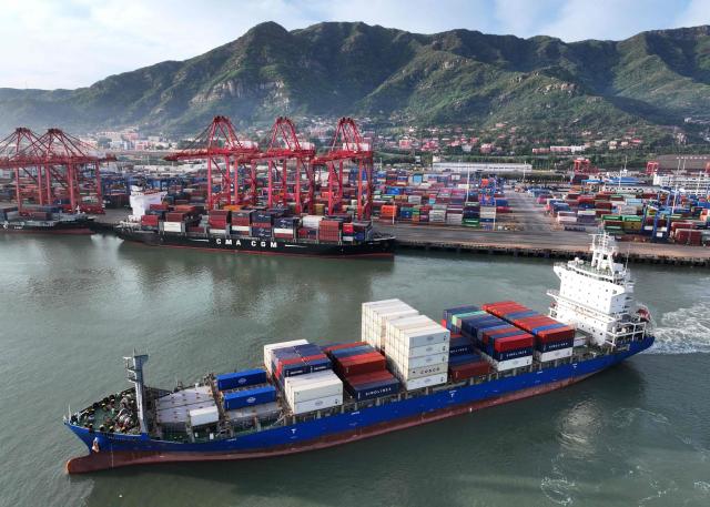 A container ship sails at the port in Lianyungang, in China’s eastern Jiangsu province early on April 23, 2026. (Photo by CN-STR / AFP) / China OUT