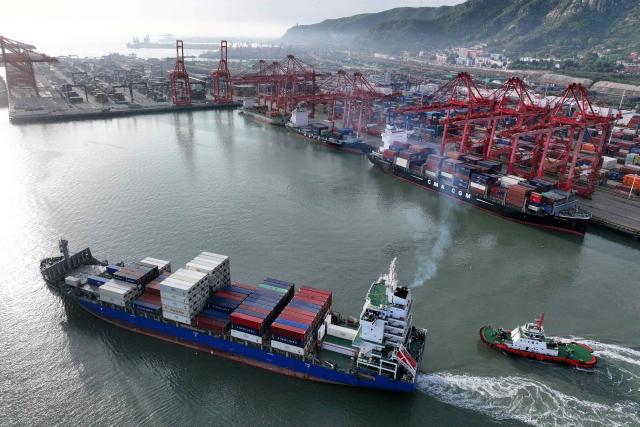 A container ship is escorted at the port in Lianyungang, in China’s eastern Jiangsu province early on April 23, 2026. (Photo by CN-STR / AFP) / China OUT