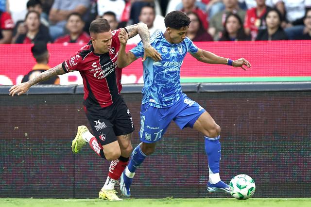 Atlas' midfielder #26 Aldo Rocha (L) and Tigres' forward #77 Ozziel Herrera fight for the ball during a Mexican League football match between Atlas and Tigres in Guadalajara, Mexico, on April 22, 2026. (Photo by Ulises Ruiz / AFP)