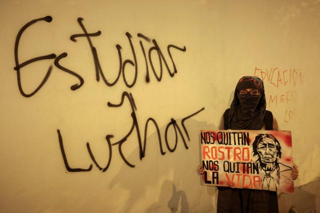 A student holds a sign reading “They take away our identity, they take away our lives” next to graffiti reading “Study and struggle” during a protest over transport fares in Lima on April 22, 2026. (Photo by Connie FRANCE / AFP)
