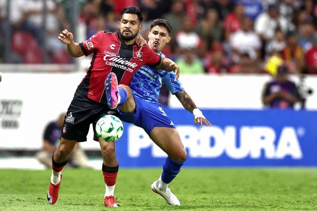 Atlas' forward #19 Eduardo Aguirre and Tigres' Brazilian midfielder #23 Romulo Zwarg fight for the ball during a Mexican League football match between Atlas and Tigres in Guadalajara, Mexico, on April 22, 2026. (Photo by Ulises Ruiz / AFP)