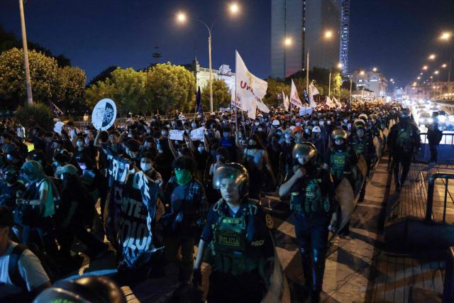 Riot police escort students protesting over transport fares in Lima on April 22, 2026. (Photo by Connie FRANCE / AFP)