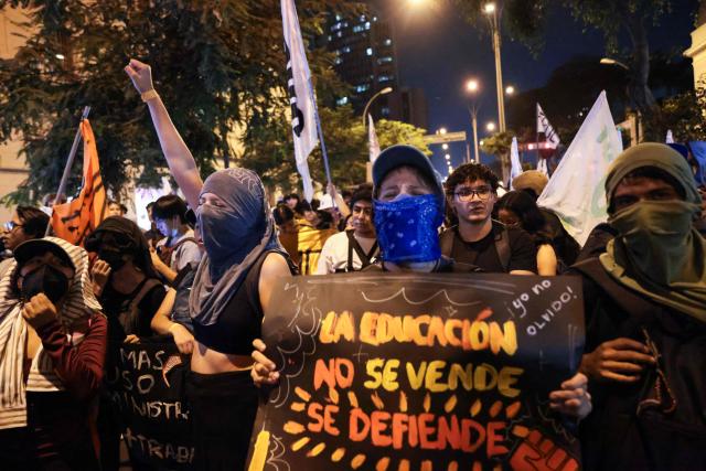 A student holds a sign reading “Education is not for sale, it is to be defended” during a protest over transport fares in Lima on April 22, 2026. (Photo by Connie FRANCE / AFP)