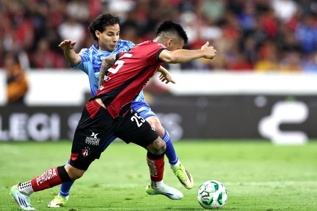 Atlas' forward #25 Jorge Rodriguez (front) and Tigres' midfielder #16 Diego Lainez fight for the ball during a Mexican League football match between Atlas and Tigres in Guadalajara, Mexico, on April 22, 2026. (Photo by Ulises Ruiz / AFP)