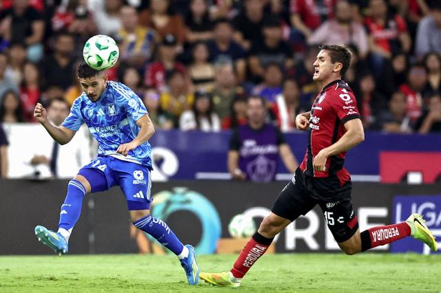 Tigres' midfielder #14 Jesus Garza and Atlas' defender #15 Paulo Ramirez fight for the ball during a Mexican League football match between Atlas and Tigres at Jalisco stadium in Guadalajara, Mexico, on April 22, 2026. (Photo by Ulises Ruiz / AFP)
