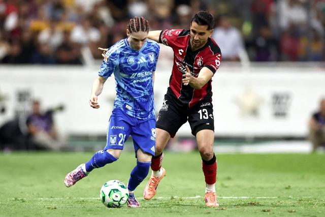 Tigres' midfielder #20 Marcelo Flores and Atlas' defender #13 Gaddi Aguirre fight for the ball during a Mexican League football match between Atlas and Tigres at Jalisco stadium in Guadalajara, Mexico, on April 22, 2026. (Photo by Ulises Ruiz / AFP)