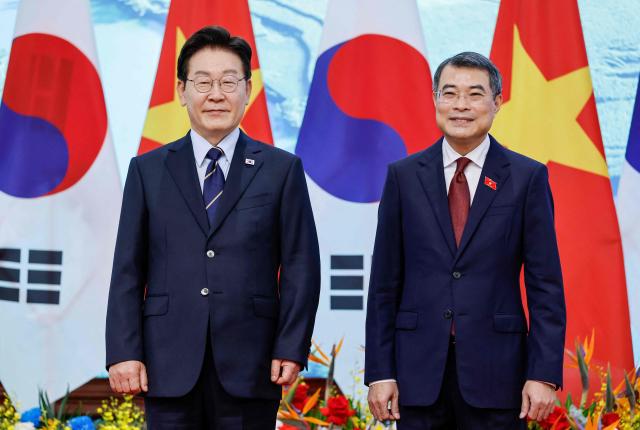 Vietnam's Prime Minister Le Minh Hung (R) and South Korea's President Lee Jae Myung (L) pose for a photo during a meeting at the Government Office in Hanoi on April 23, 2026. (Photo by LUONG THAI LINH / EPA POOL / AFP)