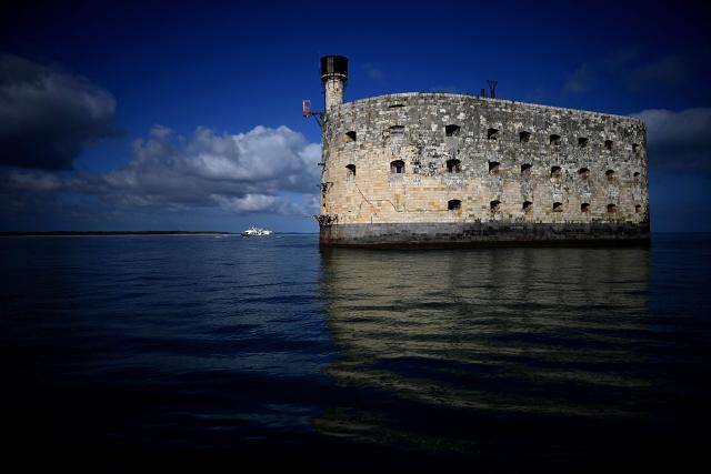 (FILES) A tourist boat sails past Fort Boyard, a famous Napoleonic ocean fortress located a few kilometres off the shore of the Ile d'Aix (Aix island) in the Atlantic ocean, western France on July 16, 2025. Cyril Feraud will become the new host of the France 2 TV channel game show "Fort Boyard" at the summer of 2026. (Photo by Christophe ARCHAMBAULT / AFP)