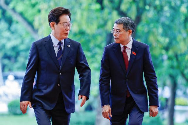 Vietnam's Prime Minister Le Minh Hung (R) and South Korea's President Lee Jae Myung (L) walk during a meeting at the Government Office in Hanoi on April 23, 2026. (Photo by LUONG THAI LINH / POOL / AFP)