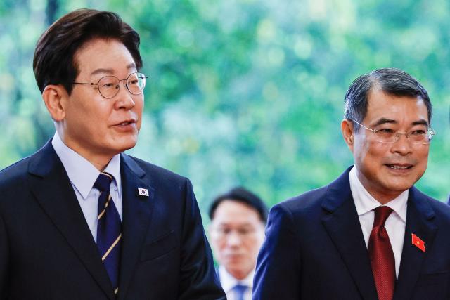 Vietnam's Prime Minister Le Minh Hung (R) and South Korea's President Lee Jae Myung (L) walk during a meeting at the Government Office in Hanoi on April 23, 2026. (Photo by LUONG THAI LINH / POOL / AFP)