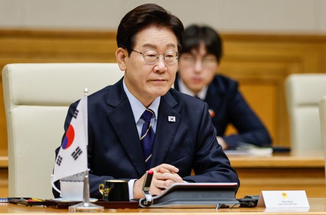 South Korea's President Lee Jae Myung sits during a meeting with Vietnam's Prime Minister Le Minh Hung at the Government Office in Hanoi on April 23, 2026. (Photo by LUONG THAI LINH / POOL / AFP)