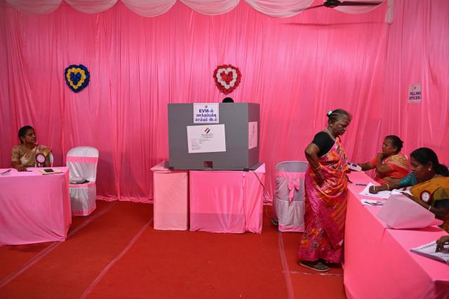 A voter arrives to cast her vote at a pink polling station, an all-women managed booth, during the Tamil Nadu Legislative Assembly elections in Chennai on April 23, 2026. Voting began on April 23 in two of India's politically key opposition-held states, with tens of millions casting ballots in West Bengal and the southern Tamil Nadu. (Photo by R.Satish BABU / AFP)