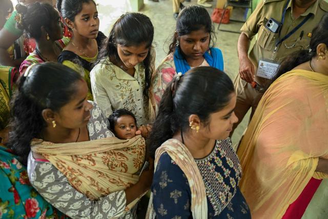 An Indian gypsy woman, along with her child, stands in a queue to cast her vote at a polling station during the Tamil Nadu Legislative Assembly elections in Chennai on April 23, 2026. Voting began on April 23 in two of India's politically key opposition-held states, with tens of millions casting ballots in West Bengal and the southern Tamil Nadu. (Photo by R.Satish BABU / AFP)