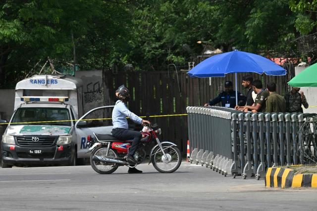 Security personnel speak with a motorcyclist as they stand at a checkpost on a closed road leading to the Serena Hotel in the Red Zone area of Islamabad on April 23, 2026. Pakistan's capital was still locked in gear on April 22 to host high-stakes US-Iran talks that were pushed back at the last minute overnight, but many residents began to tire of the heavy personal and economic toll of tight security restrictions. (Photo by Asif HASSAN / AFP)
