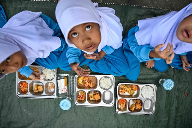 Kindergarten students eat food supplied by the Indonesian government's free meal program in Banda Aceh on April 23, 2026. (Photo by CHAIDEER MAHYUDDIN / AFP)