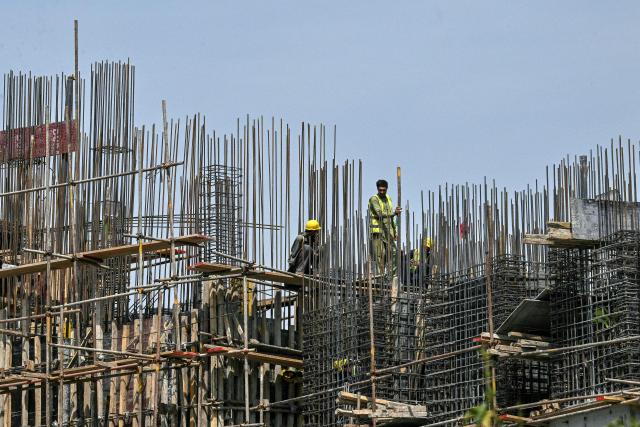 People work at the construction site of a multi-storey building in Islamabad on April 23, 2026. (Photo by Asif HASSAN / AFP)