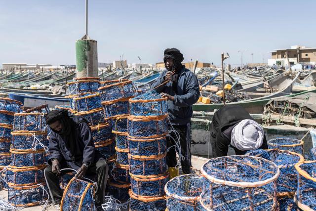 Fishermen prepare fishing baskets at the Port Artisanal in Nouadhibou, on April 22, 2026. (Photo by PATRICK MEINHARDT / AFP)
