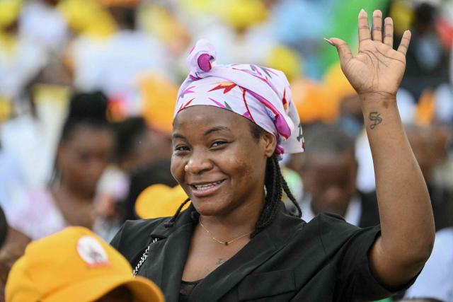 A faithful gestures before Pope Leo XIV arrives to lead a Holy Mass at the Malabo Stadium in Malabo on the last day of an 11-day apostolic journey to Africa, on April 23, 2026. (Photo by Alberto PIZZOLI / AFP)