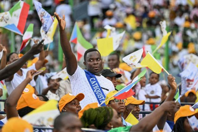 A faithful gestures before Pope Leo XIV arrives to lead a Holy Mass at the Malabo Stadium in Malabo on the last day of an 11-day apostolic journey to Africa, on April 23, 2026. (Photo by Alberto PIZZOLI / AFP)