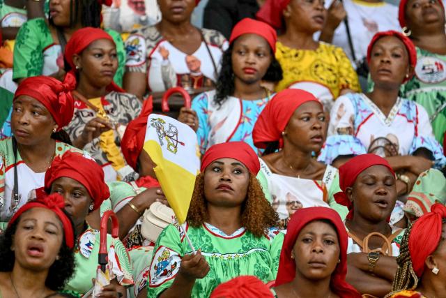 A faithful holds a Vatican flag before Pope Leo XIV arrives to lead a Holy Mass at the Malabo Stadium in Malabo on the last day of an 11-day apostolic journey to Africa, on April 23, 2026. (Photo by Alberto PIZZOLI / AFP)