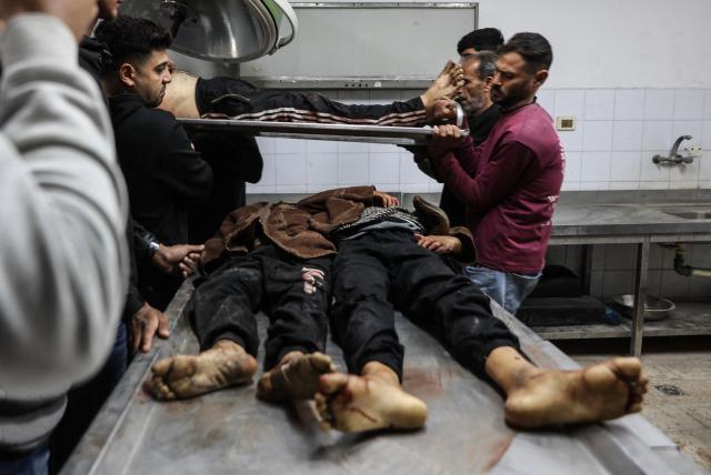 EDITORS NOTE: Graphic content / Mourners carry the bodies of Palestinians killed in a reported Israeli airstrike the previous night during their funeral at Al-Shifa Hospital in Gaza City on April 23, 2026. Gaza's civil defence agency said an Israeli airstrike targeted a group of civilians in a northern part of the Palestinian territory late on April 22, killing five people including three children. Despite an October 10 ceasefire, Gaza remains gripped by daily violence as both the Israeli military and Hamas accuse one another of breaking the truce. (Photo by Omar AL-QATTAA / AFP)