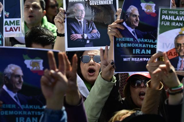 Supporter of son of Iran's last shah, exiled Crown Prince Reza Pahlavi attend a demonstration in Berlin, on April 23, 2026. Pahlavi said during a press conference that any negotiation with the religious authorities in Tehran amounted to a "policy of appeasement," expressing hope that new protests would eventually overthrow the regime. (Photo by John MACDOUGALL / AFP)