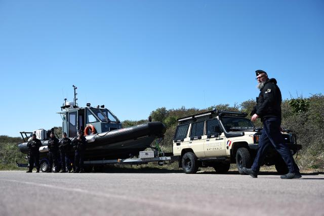 French gendarmes stand as they wait for France's Interior Minister and British Home Secretary's visit for a presentation of the operational resources used to counter illegal immigration, on the shores of Zuydcoote, near Dunkirk, on April 23, 2026. Britain and France have agreed a new three-year deal to stop undocumented migrants making the risky journey across the Channel in small boats, the two sides announced. Under the deal, France pledged to increase law enforcement on the coast by more than half to fight irregular migration to Britain -- reaching 1,400 officers by 2029. The Sandhurst treaty sets out the UK's financial contribution to French efforts to stop migrants attempting the perilous sea crossing to Britain. (Photo by Sameer AL-DOUMY / AFP)