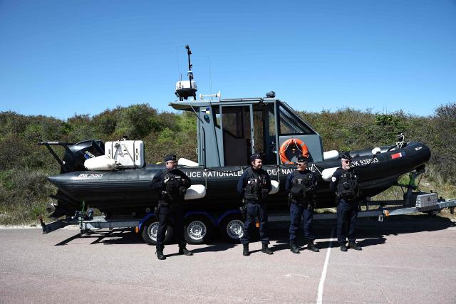 French gendarmes stand as they wait for France's Interior Minister and British Home Secretary's visit for a presentation of the operational resources used to counter illegal immigration, on the shores of Zuydcoote, near Dunkirk, on April 23, 2026. Britain and France have agreed a new three-year deal to stop undocumented migrants making the risky journey across the Channel in small boats, the two sides announced. Under the deal, France pledged to increase law enforcement on the coast by more than half to fight irregular migration to Britain -- reaching 1,400 officers by 2029. The Sandhurst treaty sets out the UK's financial contribution to French efforts to stop migrants attempting the perilous sea crossing to Britain. (Photo by Sameer AL-DOUMY / AFP)