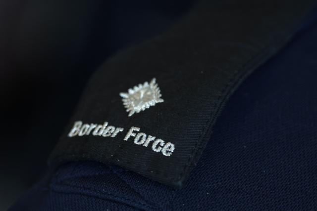 This photograph shows the patch of the British Border Force worn by an officer in the French Border Police office of Loon-Plage, near Dunkirk, on April 23, 2026. Britain and France have agreed a new three-year deal to stop undocumented migrants making the risky journey across the Channel in small boats, the two sides announced. Under the deal, France pledged to increase law enforcement on the coast by more than half to fight irregular migration to Britain -- reaching 1,400 officers by 2029. The Sandhurst treaty sets out the UK's financial contribution to French efforts to stop migrants attempting the perilous sea crossing to Britain. (Photo by Sameer AL-DOUMY / AFP)