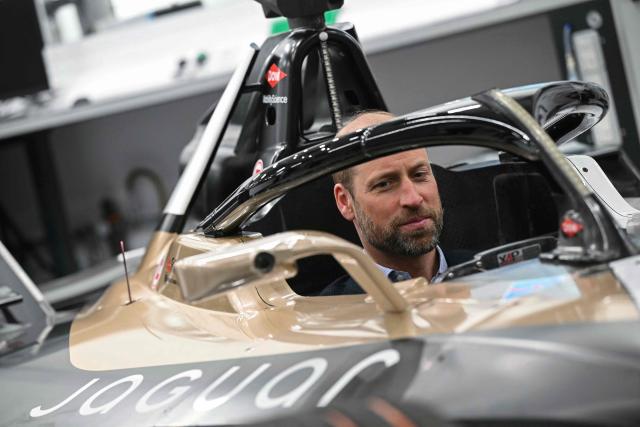 Britain's Prince William (L), Prince of Wales, sits inside a car during a visit to the headquarters of British Formula E team, Jaguar TCS Racing, at Kidlington, Oxfordshire, west of London on April 23, 2026. (Photo by JUSTIN TALLIS / POOL / AFP)