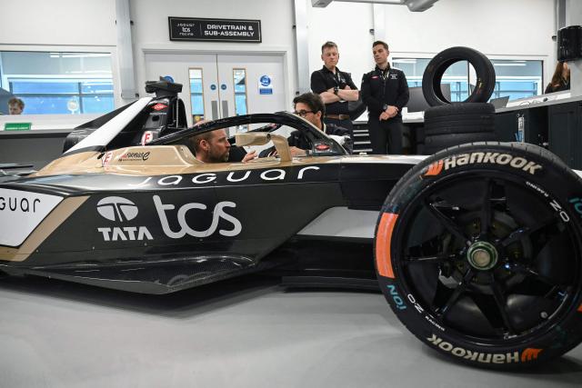 Britain's Prince William (L), Prince of Wales, sits inside a car during a visit to the headquarters of British Formula E team, Jaguar TCS Racing, at Kidlington, Oxfordshire, west of London on April 23, 2026. (Photo by JUSTIN TALLIS / POOL / AFP)