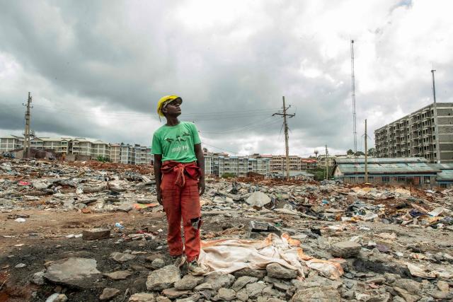 Kule Tosh, a resident of Soweto Zone D, looks at buildings under construction for a state affordable housing programme following government-planned demolitions carried out to make space for the project at the Kibera informal settlement, in Nairobi on April 23, 2026. Kenyas Affordable Housing Programme is a government initiative to replace informal settlements with low-cost housing. In Kibera, the largest informal settlement in Kenya, demolitions have cleared some areas for new developments aimed at improving living conditions and home ownership. However, the programme has faced controversy over evictions, compensation and displacement of residents before completion of new housing. (Photo by Gordwin Odhiambo / AFP)