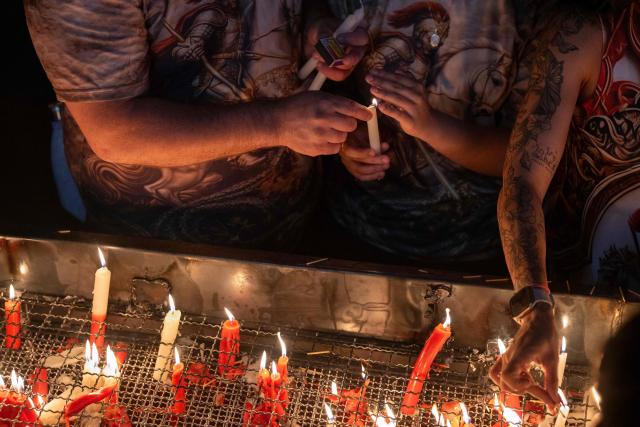 People light candles during Saint George's Day (Sao Jorge) celebrations at the Quintino neighborhood in Rio de Janeiro, Brazil on April 23, 2026. (Photo by Pablo PORCIUNCULA / AFP)